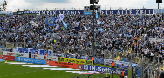 Blick von der Stehhalle auf die gut gefüllte Westkurve beim Heimsieg der Löwen gegen den SC Freiburg II bei schönstem Wetter