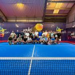 Padel bei den Löwen – Mit dem Löwen auf der Brust und dem Schläger in der Hand Spieler*innen der Padel Sparte stehen auf einem Court im Padelon für ein Gruppenfoto.